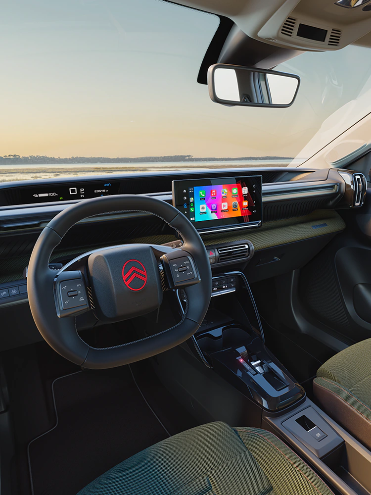 Vue depuis le poste de conduite de la Citroën C3 Outdoor avec tableau de bord et écran tactile, mettant en avant la connectivité Advanced Comfort pour les trajets en SUV compact.