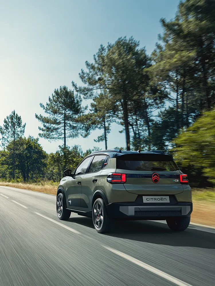 Vue arrière trois quarts de la Citroën C3 Outdoor avec feux arrière à LED, illustrant le SUV compact Advanced Comfort sur une route dégagée.