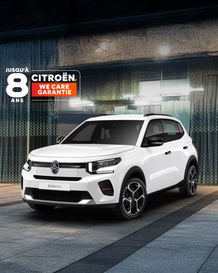 Vue de trois quarts avant de la Citroën ë-C3 Van garée en milieu urbain, mettant en valeur son design moderne et ses proportions compactes.