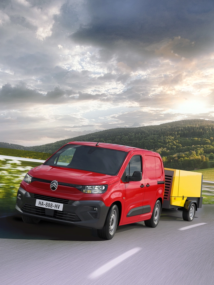 Berlingo Van tractant une remorque sur une route de campagne, illustrant le contrôle de stabilité de la remorque pour un remorquage plus sûr.