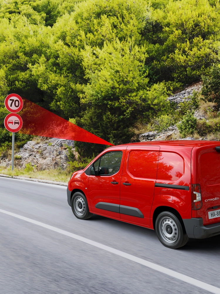 Fourgon rouge identifiant plusieurs panneaux de signalisation devant lui et affichant la reconnaissance étendue de la vitesse et les recommandations.