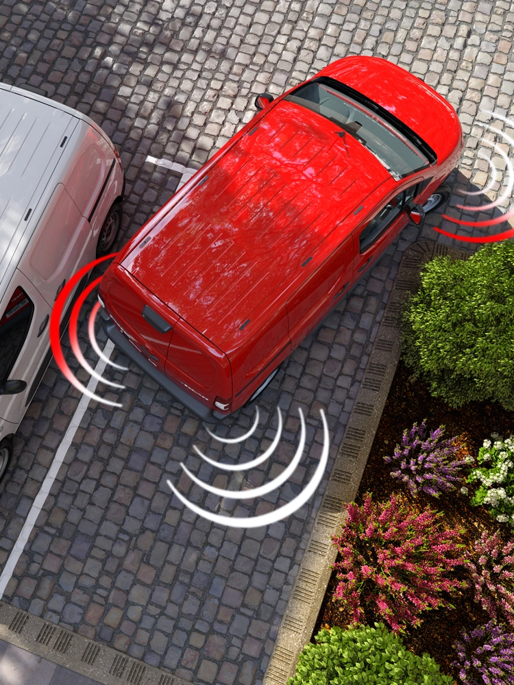 Vue aérienne d'un Berlingo Van utilisant des capteurs de stationnement avant et arrière pour détecter les obstacles à proximité en milieu urbain.