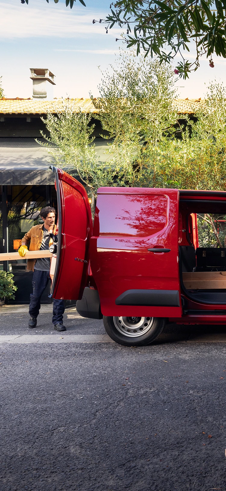 Vue de profil d'un Citroën ë-Berlingo Van avec la porte coulissante ouverte, mettant en avant sa polyvalence, son côté pratique et son adaptation aux activités professionnelles quotidiennes.