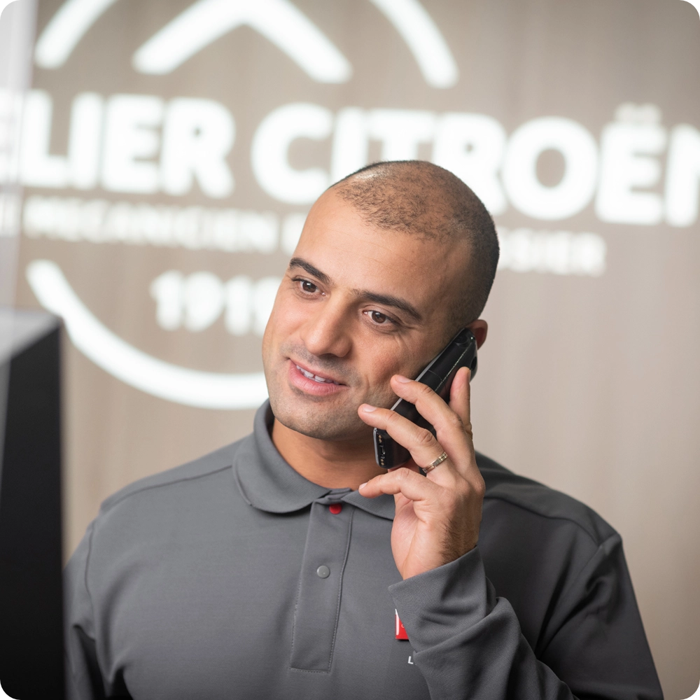 Conseiller de service dans un atelier Citroën, mettant en avant les services d'entretien préventif et l'accompagnement professionnel destinés aux propriétaires de Citroën ë-C3 Van.