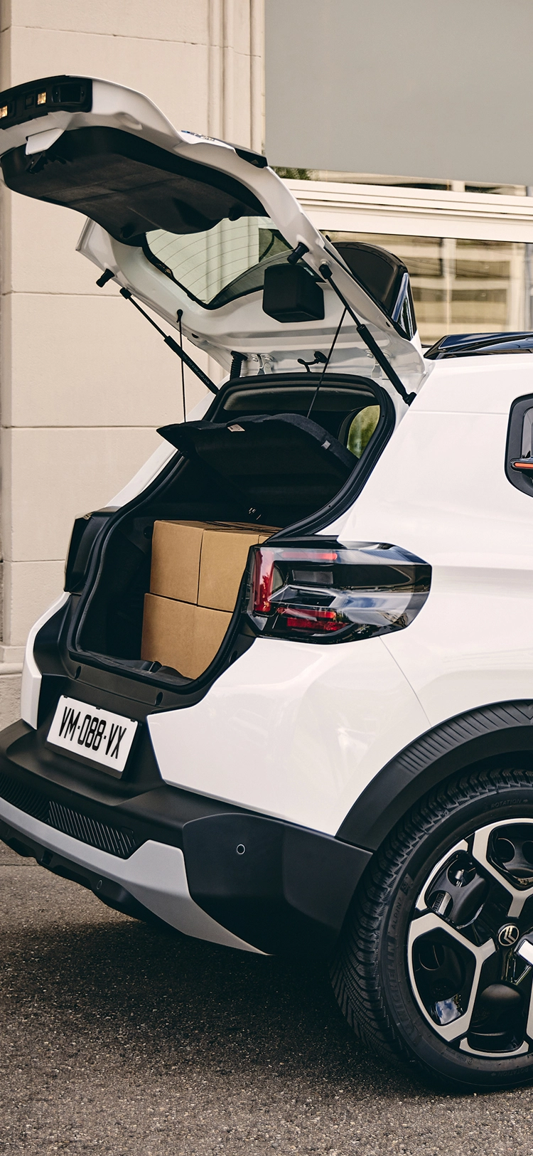 Vue de trois-quarts arrière latérale du Citroën ë-C3 Van avec le compartiment de chargement ouvert, mettant en avant l'accessibilité et la facilité de chargement. Afficher plus de lignes