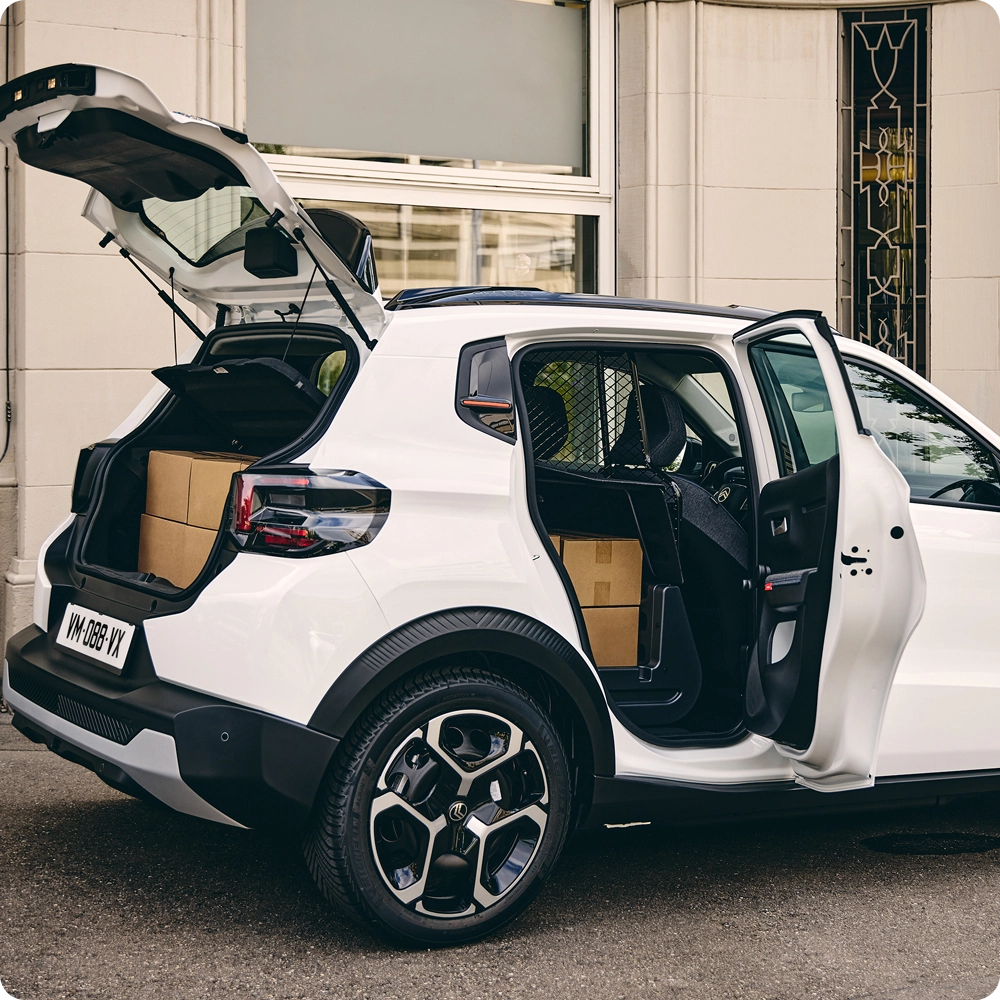 Vue arrière de trois quarts de la Citroën ë-C3 Van avec le hayon et la portière passager ouverts, mettant en avant l'accessibilité du coffre, les solutions de chargement polyvalentes et le style inspiré des SUV.