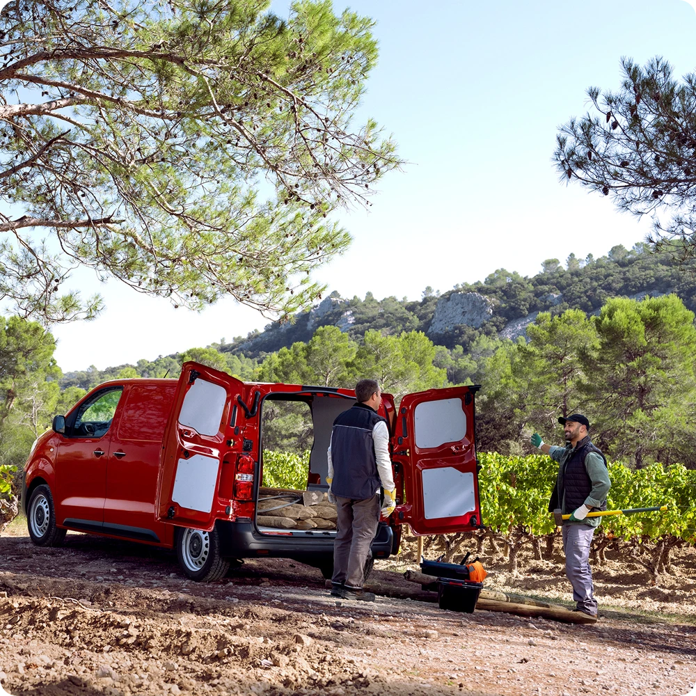 Vue arrière trois-quarts d'une Citroën ë-Jumpy rouge, portes arrière ouvertes pendant le chargement, mettant en avant l'espace de chargement polyvalent, l'accès pratique et l'aptitude à un usage professionnel.