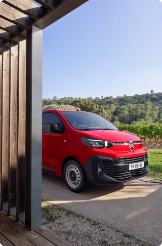 Vue arrière de trois quarts d'un Citroën ë-Jumpy rouge en cours de chargement, mettant en avant sa conception robuste, son utilisation quotidienne intensive et l'accès pratique à l'espace de chargement.
