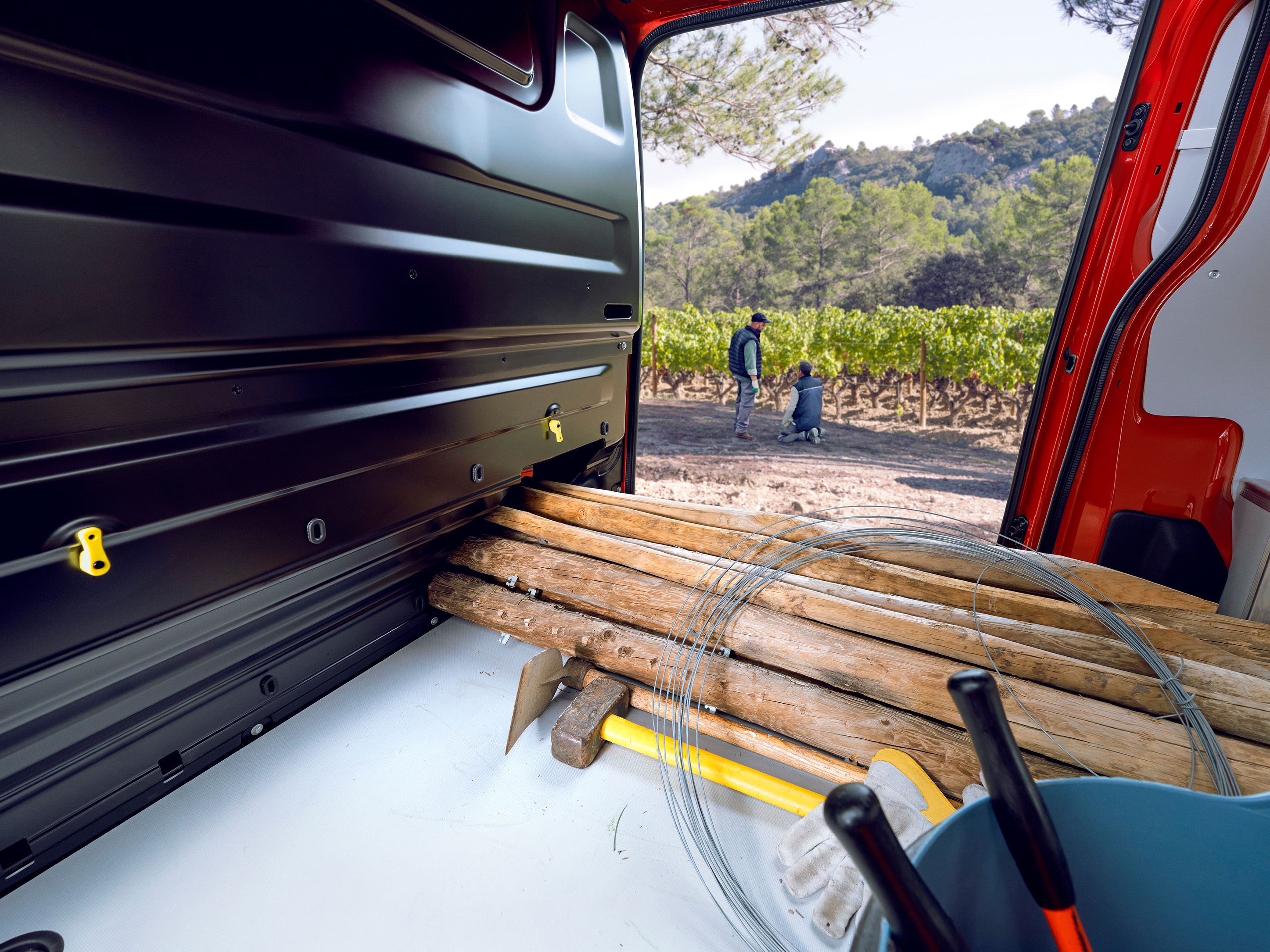 Vue intérieure de l'espace de chargement depuis l'arrière d'un Citroën Jumpy montrant de longues pièces en bois chargées à l'intérieur, mettant en avant l'espace de chargement polyvalent et l'utilisation professionnelle pratique.