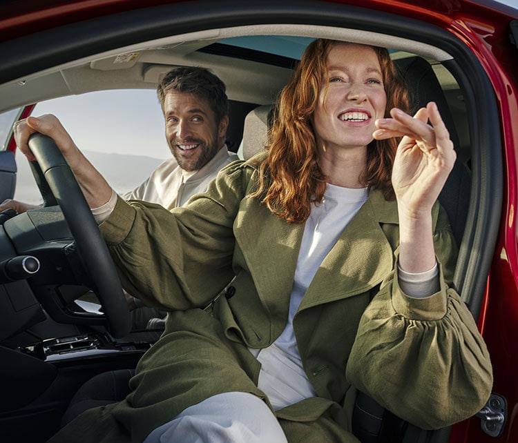 Man och kvinna ombord på Citroën ë-C4 Electric, öppen dörr