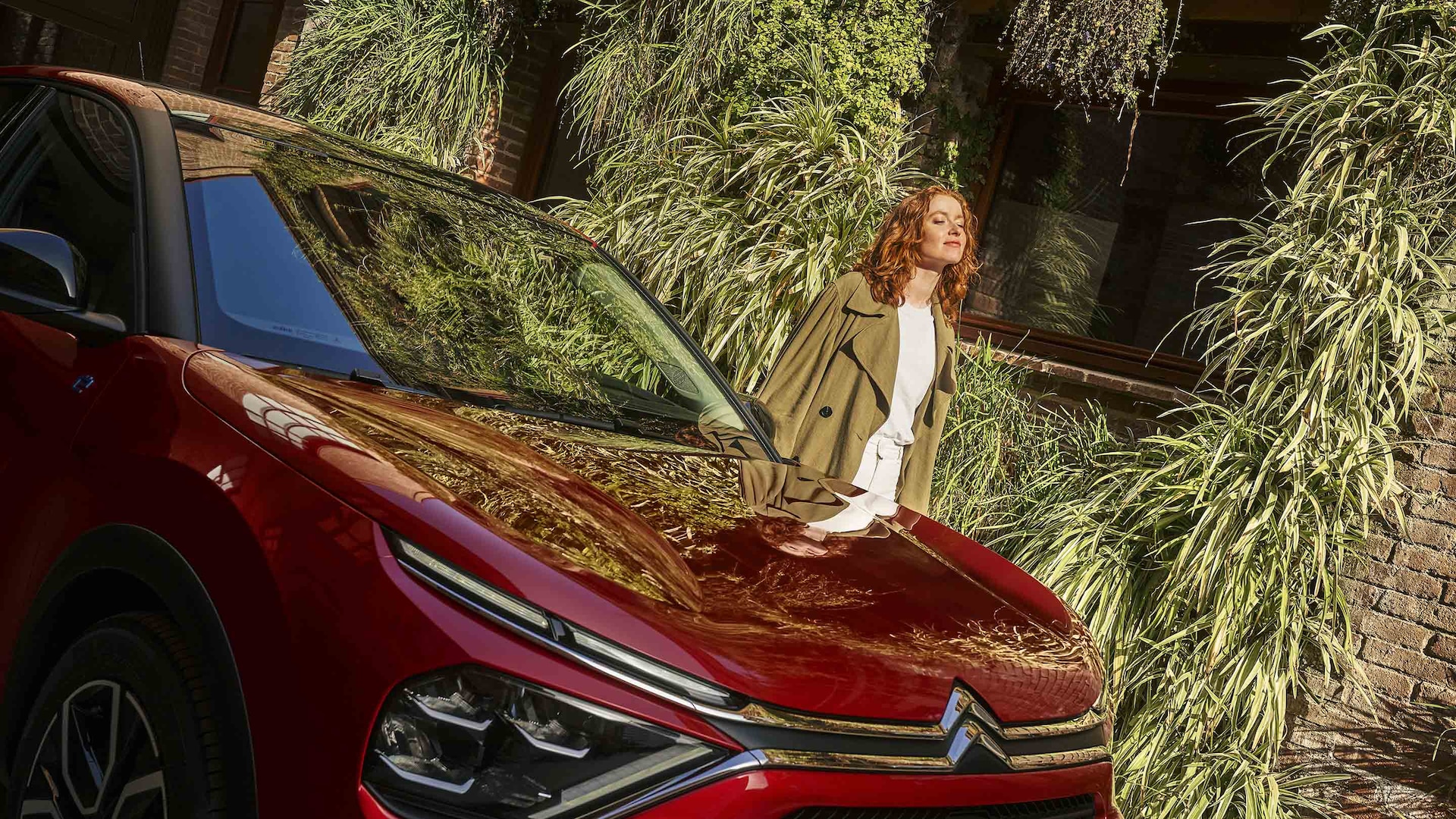 Femme souriante à côté d’une voiture en leasing social Citroën