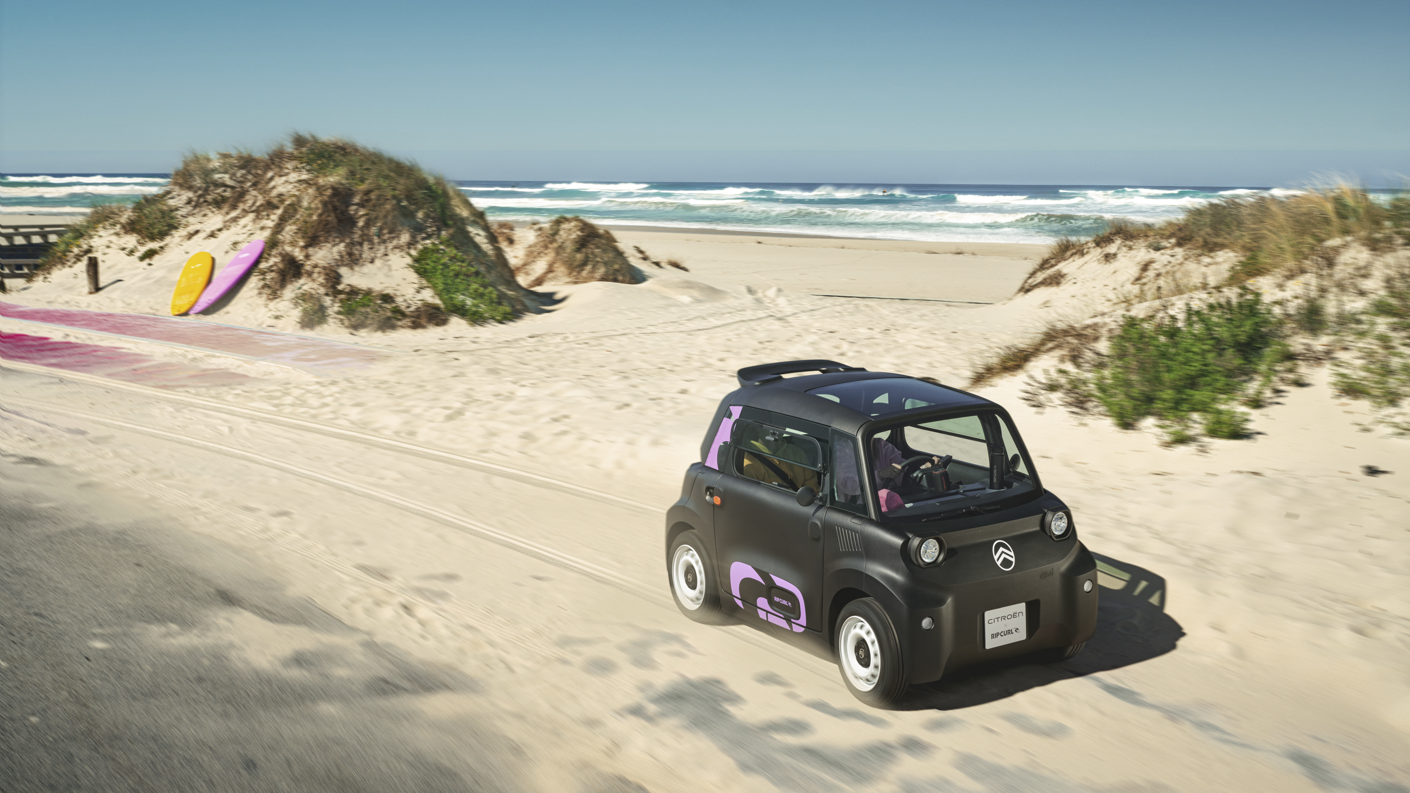 Vue de trois quarts avant en action de la Citroën Ami x Rip Curl électrique sans permis, la liberté de la Citroën Ami pour la mobilité urbaine électrique