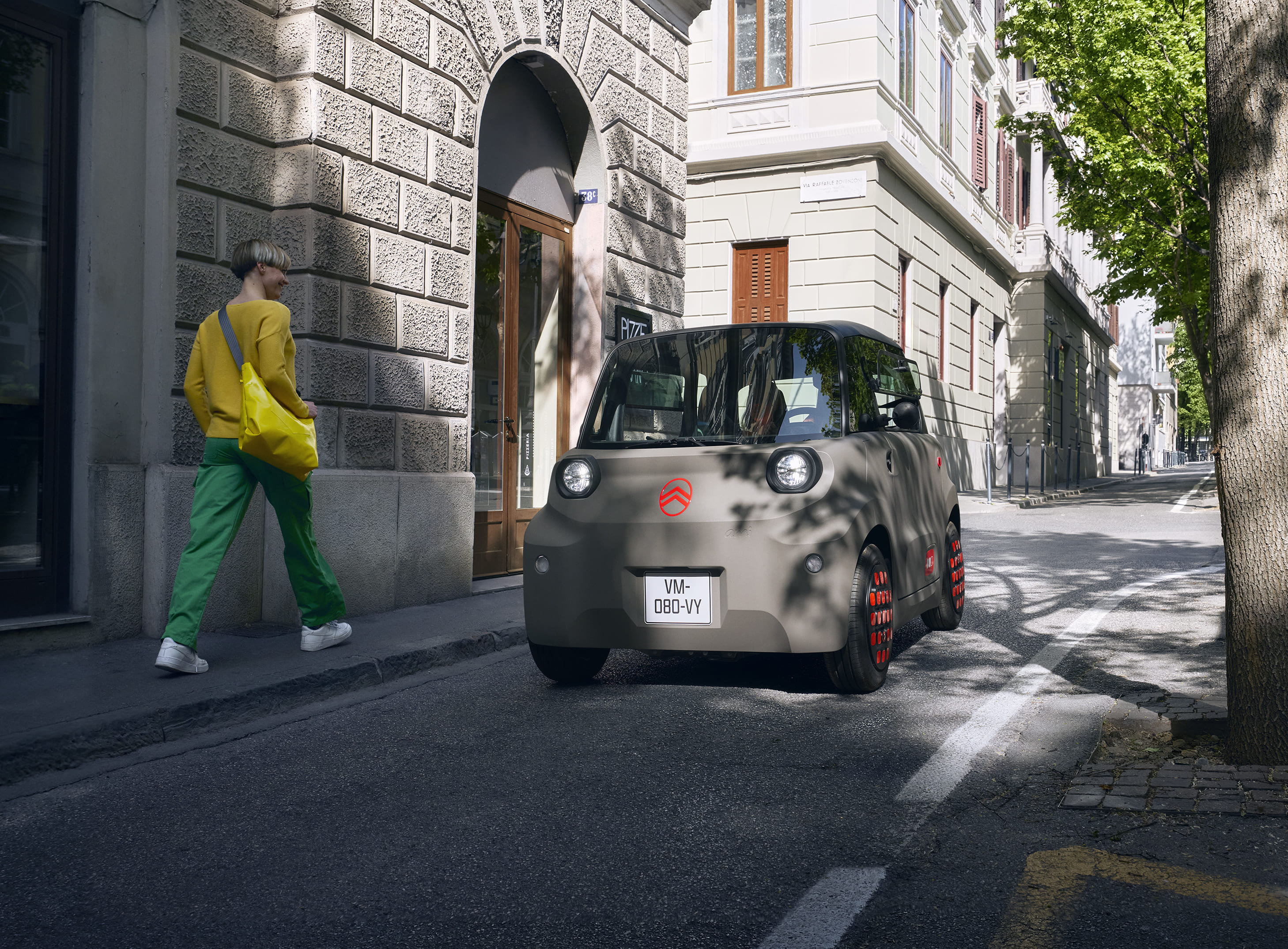 Vue de rue de face à 3/4 de la Citroën Ami met en avant un design électrique compact, sûr et fiable offrant une liberté urbaine innovante.