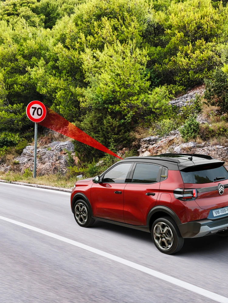 Vue côté de Citroën ë-C3 en conduite, la reconnaissance des limitations de vitesse pour mobilité plus sûre.