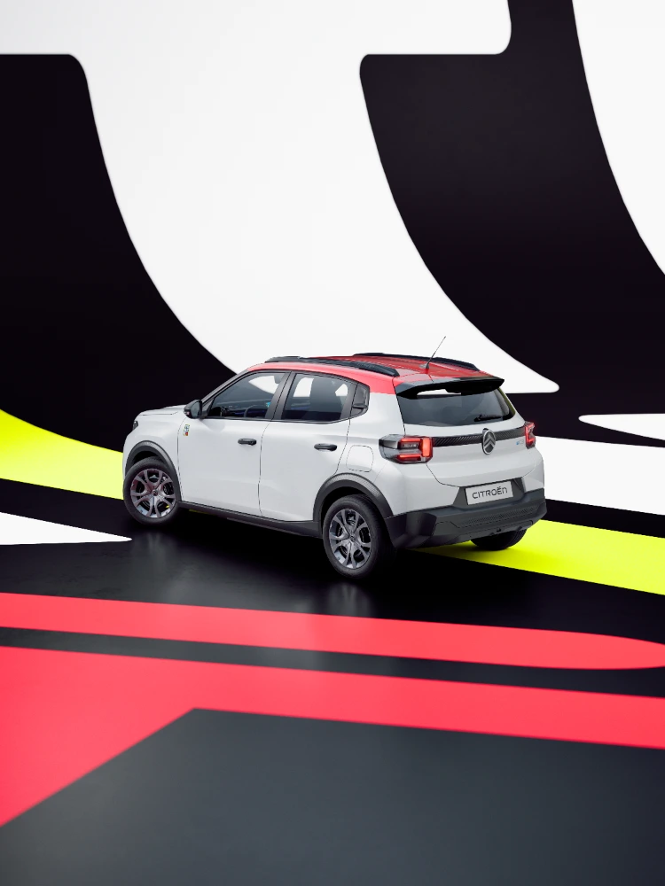 Vue arrière trois-quarts ë-C3 TONIC, voiture électrique urbaine en édition limitée, avec un fond graphique audacieux et un design compact, une alternative EV intelligente