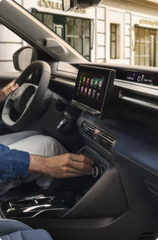 Vue intérieure côté conducteur de la citadine électrique Citroën ë-C3, avec ses commandes d'infodivertissement et de direction avancées pour un confort au quotidien, une alternative électrique intelligente