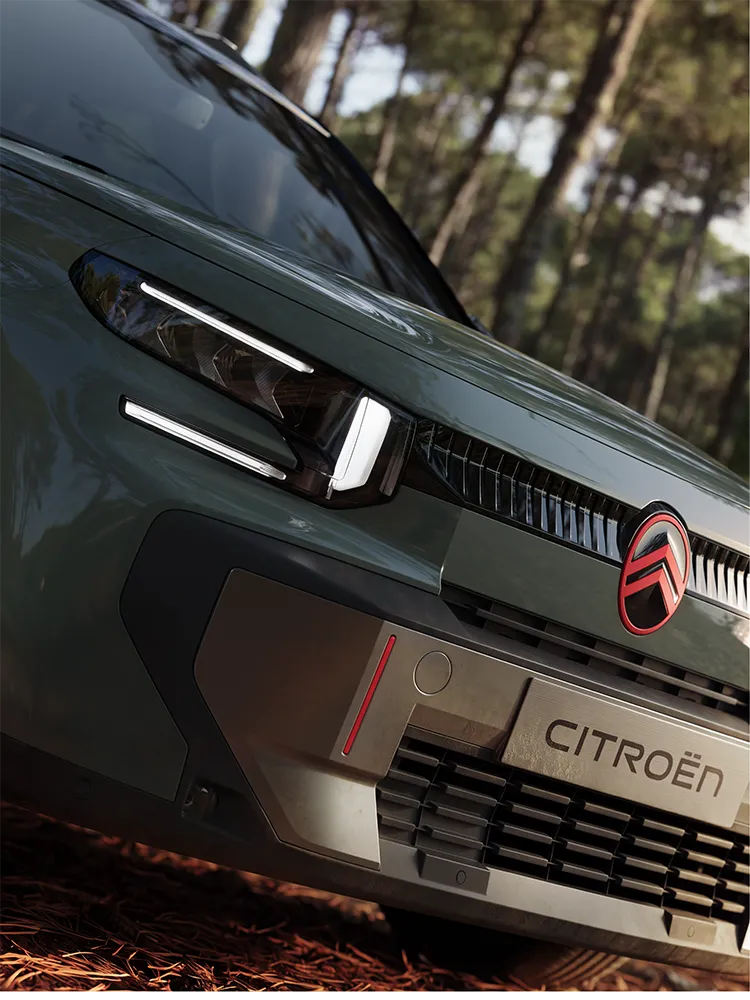 Vue rapprochée trois quarts avant du Citroën ë-C3 Aircross OUTDOOR, mettant en valeur sa signature lumineuse LED, le programme Advanced Comfort et son style affirmé de SUV familial.