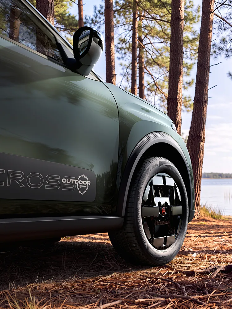 Vue rapprochée de profil du SUV Citroën ë-C3 Aircross OUTDOOR, mettant en avant le design spécifique de ses jantes Outdoor, le programme Advanced Comfort et son esprit d’aventure familial.