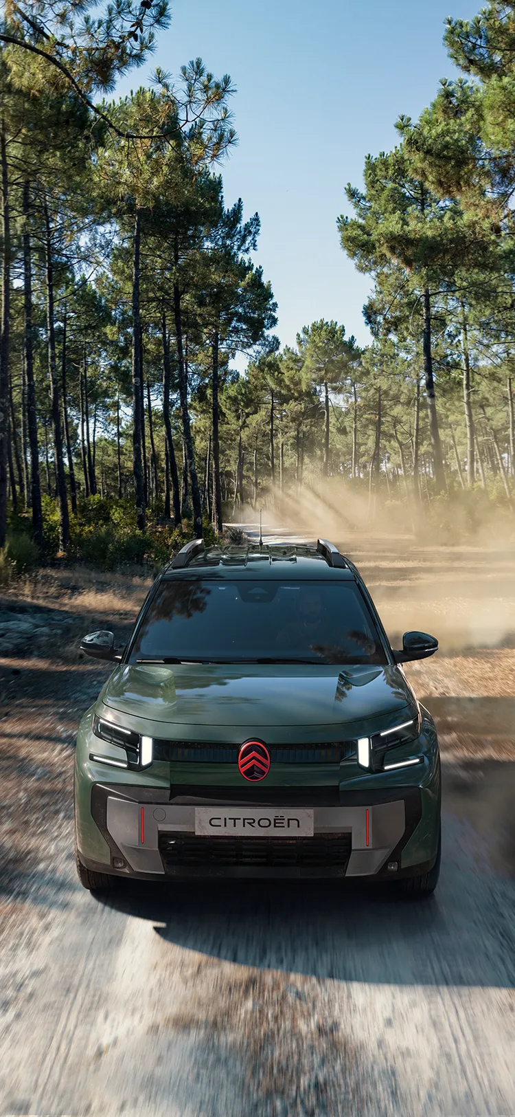 Vue aérienne avant du SUV Citroën C3 Aircross OUTDOOR, mettant en valeur sa signature lumineuse LED, le programme Advanced Comfort et son caractère de SUV familial sur un chemin forestier.