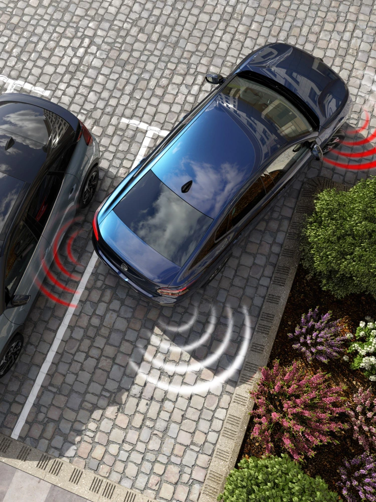 Vue aérienne de la Citroën ë-C4 X montrant les capteurs de stationnement avant et arrière actifs pendant les manœuvres