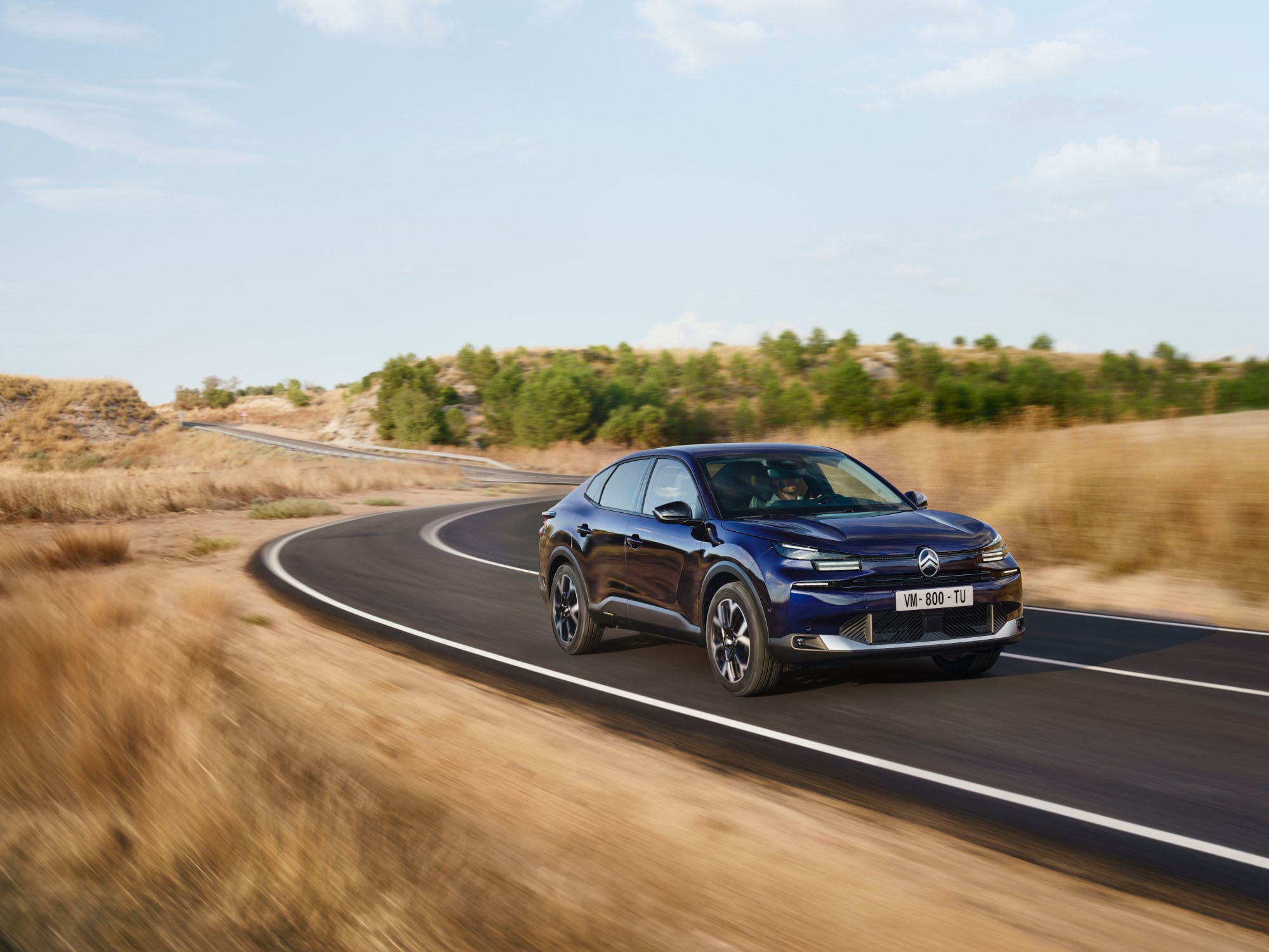 Vue 3/4 avant de la Citroën ë-C4 X en mouvement, avec son design fastback mobilité abordable