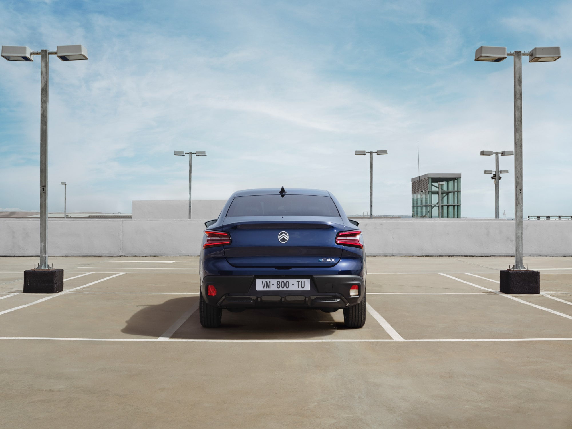 Vue arrière de la Citroën ë-C4 X parking, avec son design fastback mobilité abordable