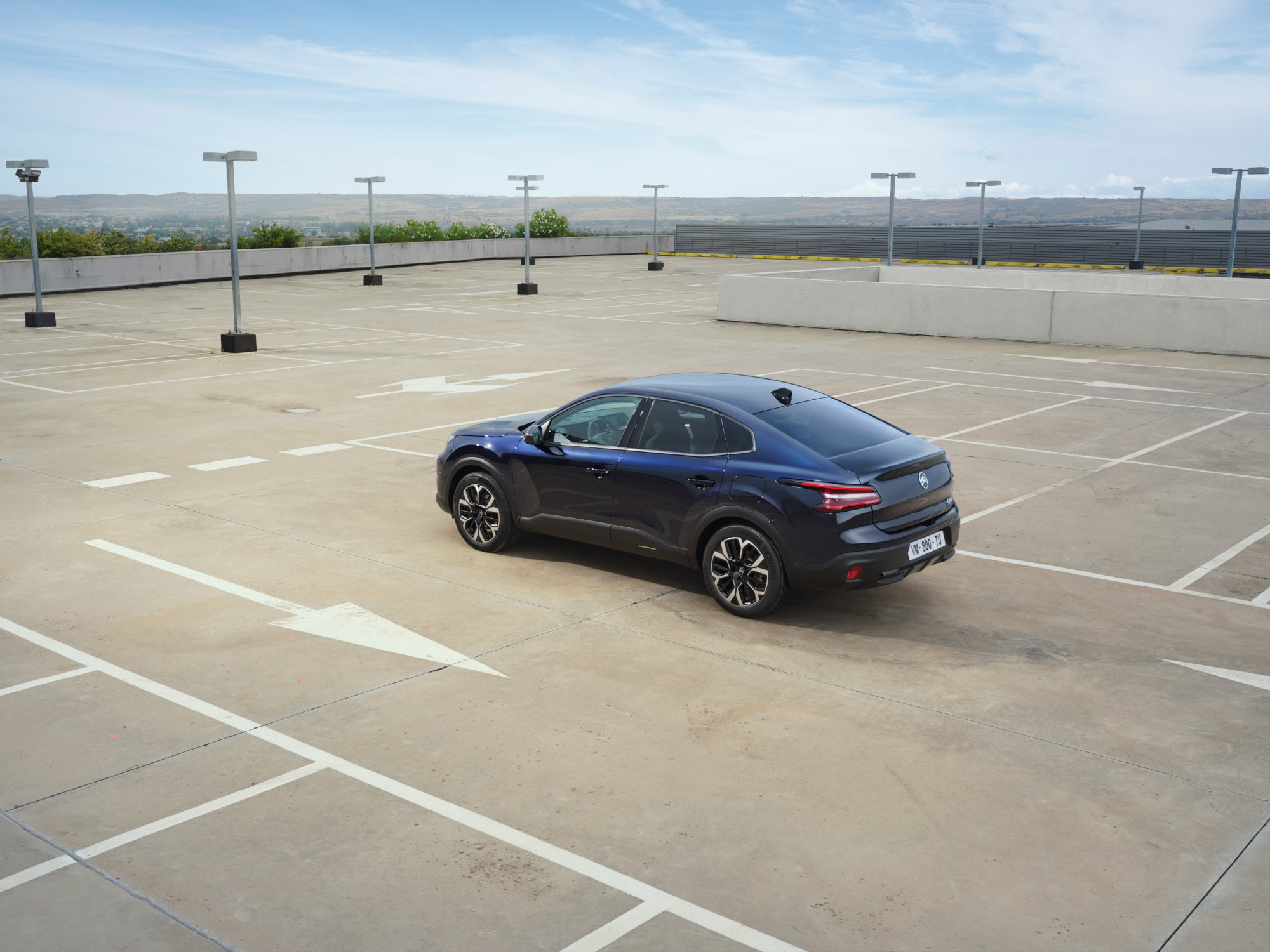 Vue 3/4 arrière de la Citroën ë-C4 X parking, avec ses lignes fastback mobilité abordable