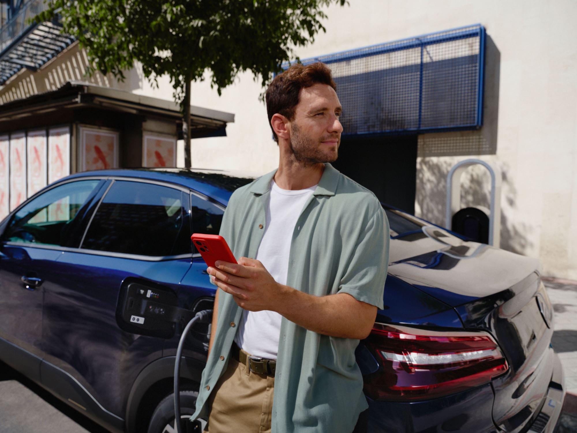 Scène de recharge connectée de la Citroën ë-C4 X fastback illustrant l'utilisation d'une application intelligente