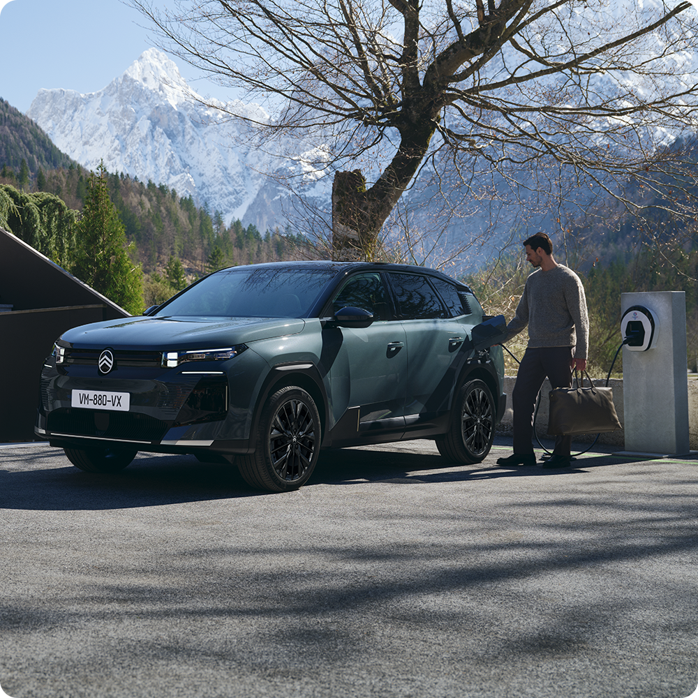 Vue avant de la ë-C5 Aircross en charge à domicile, mettant en avant la sécurité, l’efficience, les technologies embarquées et la praticité d’utilisation au quotidien.