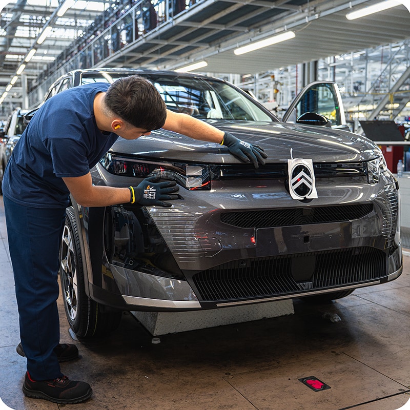 Vue de la Citroën ë-C5 Aircross en cours d’assemblage dans un environnement industriel, mettant en avant la qualité de fabrication et le savoir‑faire de production.