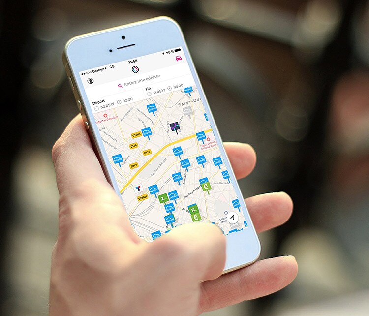 Mão segurando um smartphone para ver os terminais no aplicativo Free2Move