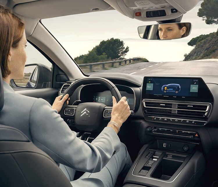 Donna al volante dell'ibrido ricaricabile Aircross Citroën C5