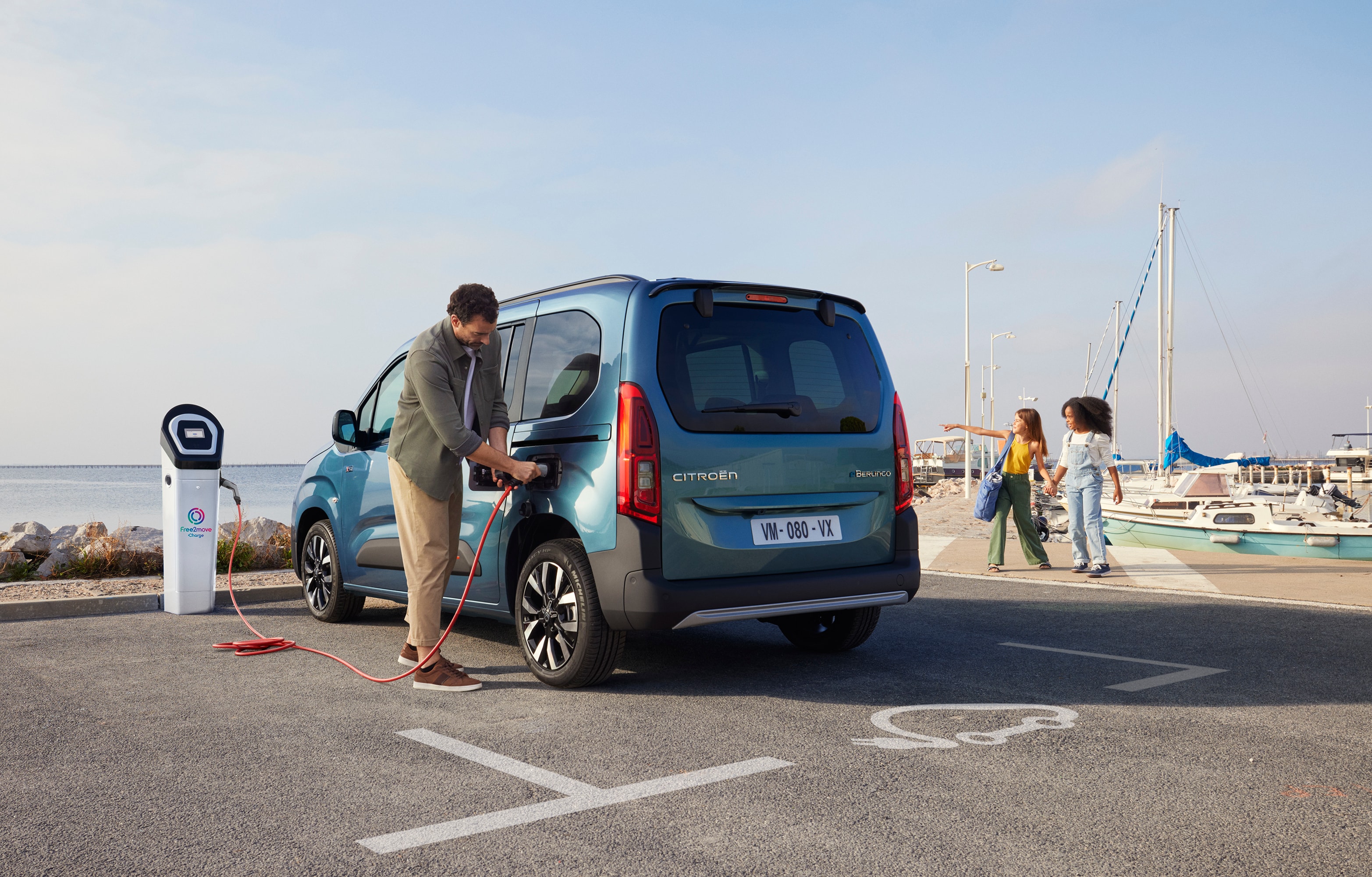 Vue 3/4 arrière de ë-Berlingo en cours de recharge à une station Free2move, avec la sécurité, l'efficacité