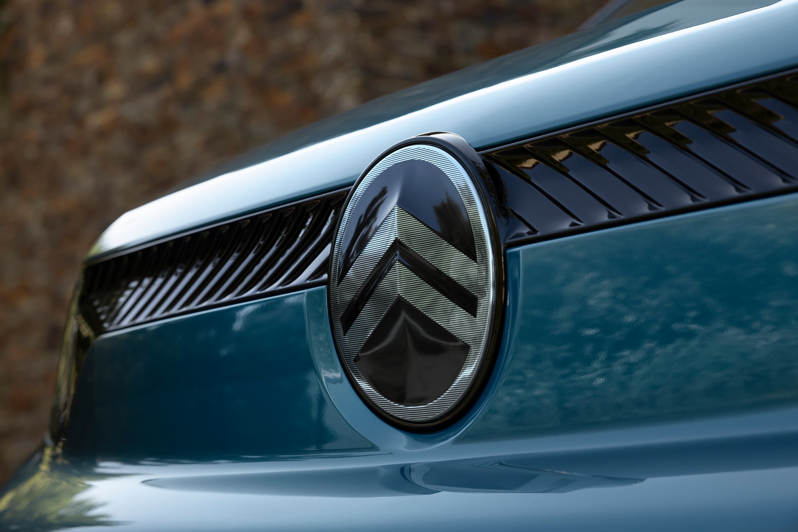 Vue détaillée de l'avant de ë-Berlingo en bleu Kiama, avec le nouveau design du logo Citroën, la qualité