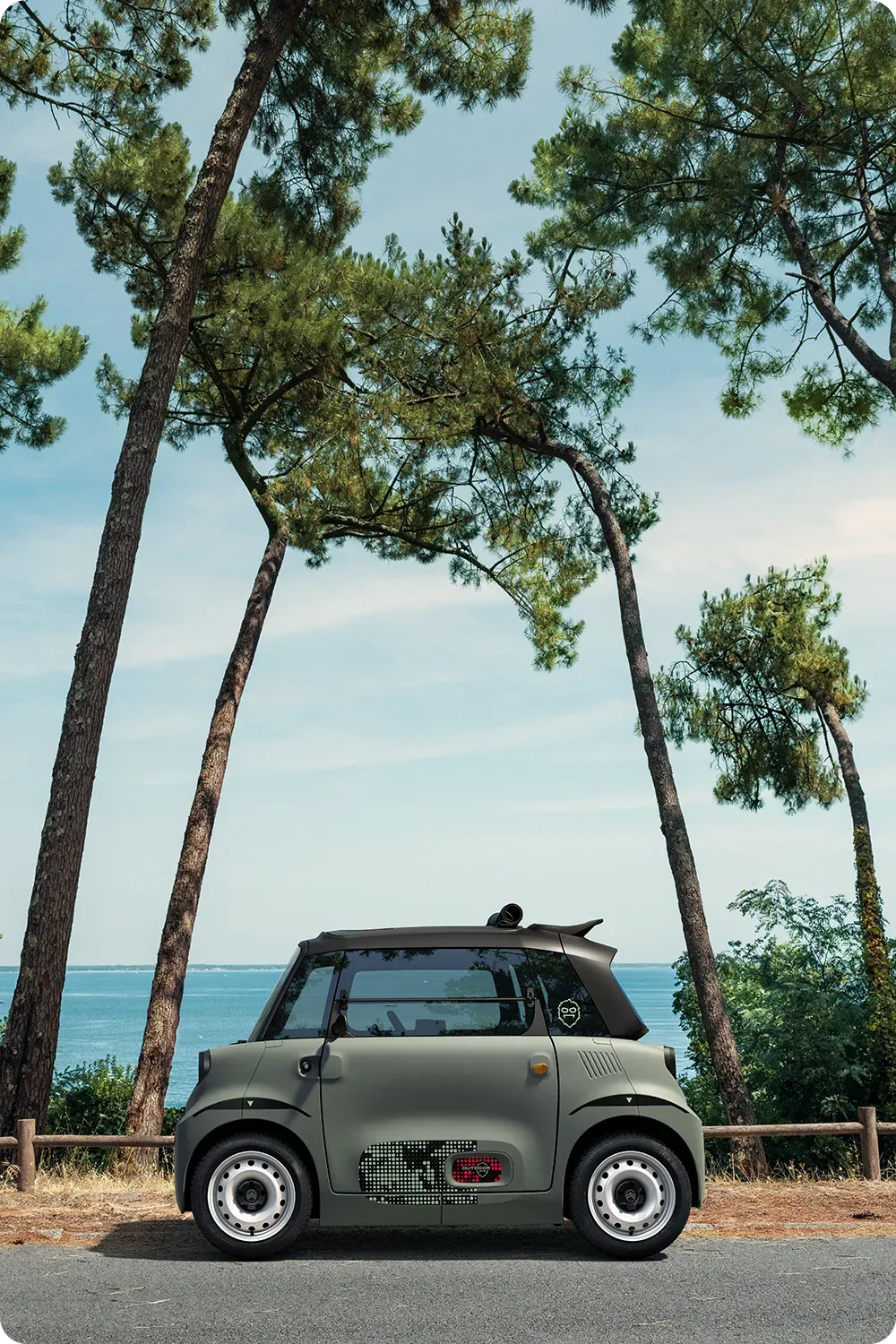 Vue de profil de la Citroën ami Outdoor, quadricycle compact, électrique et accessible, au design innovant pour la mobilité urbaine en bord de mer.