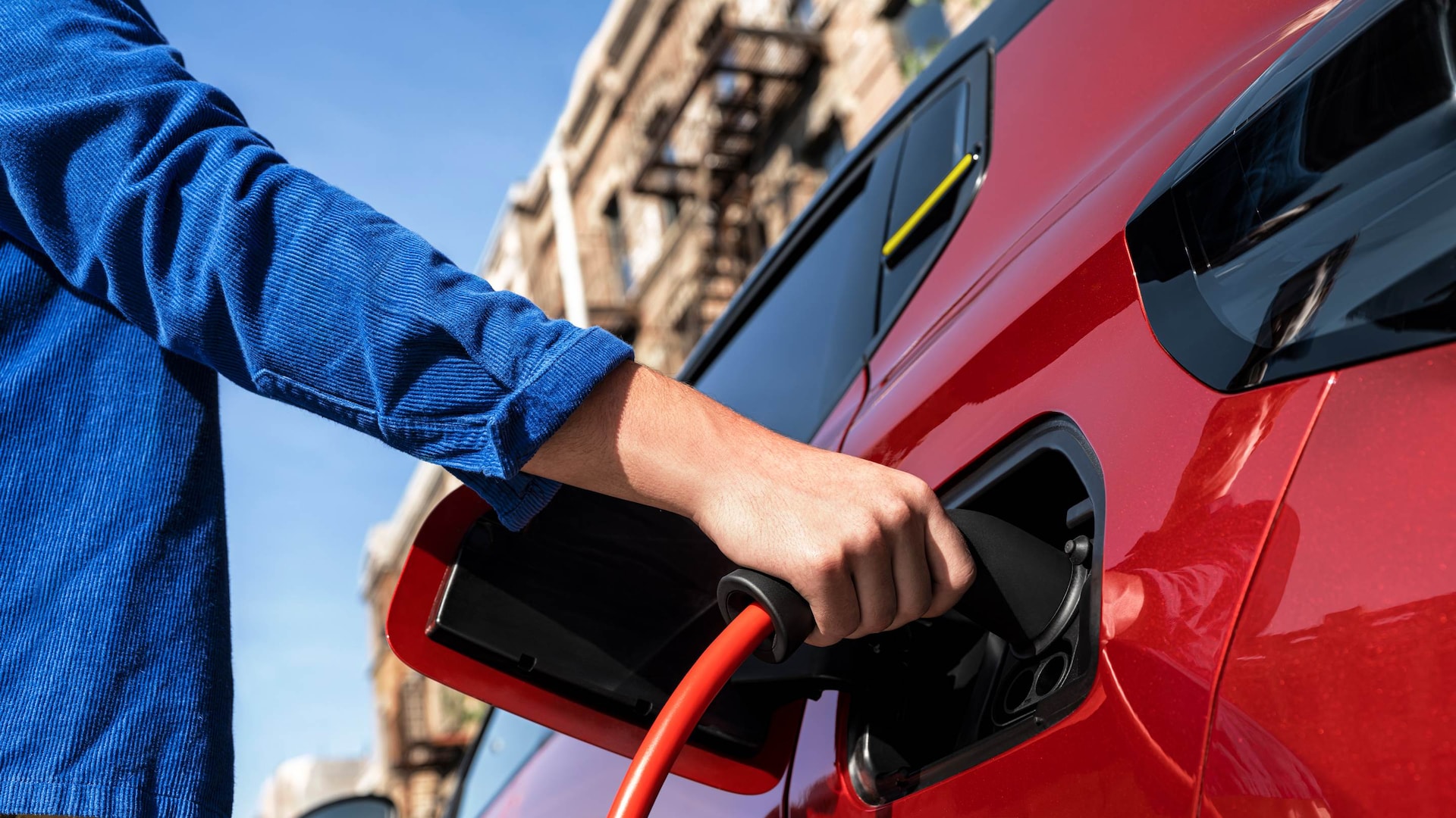 femme en train de recharger sa voiture dans le cadre du leasing electrique