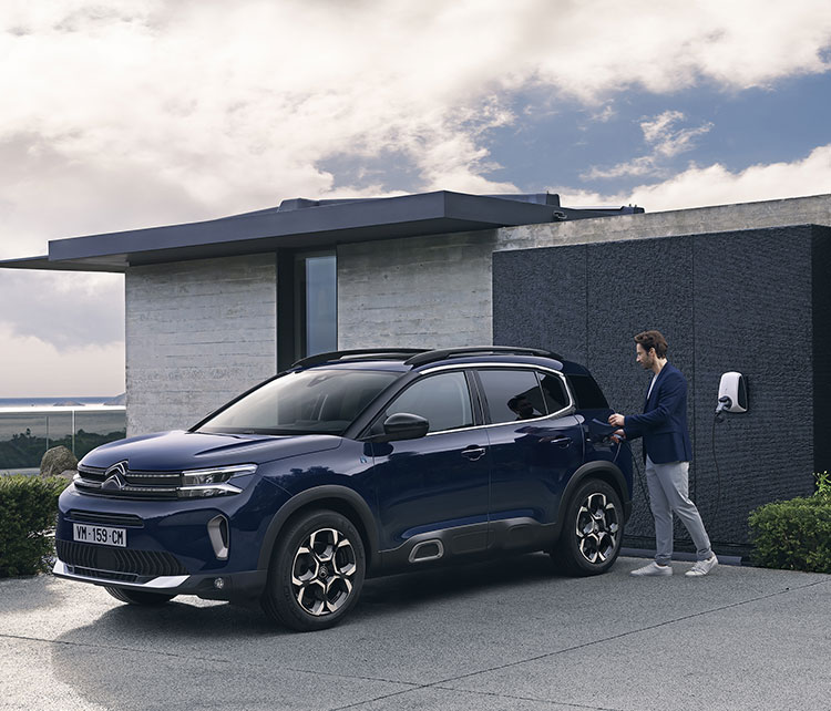 Uomo che ricarica Citroën C5 Aircross nel corso di una casa